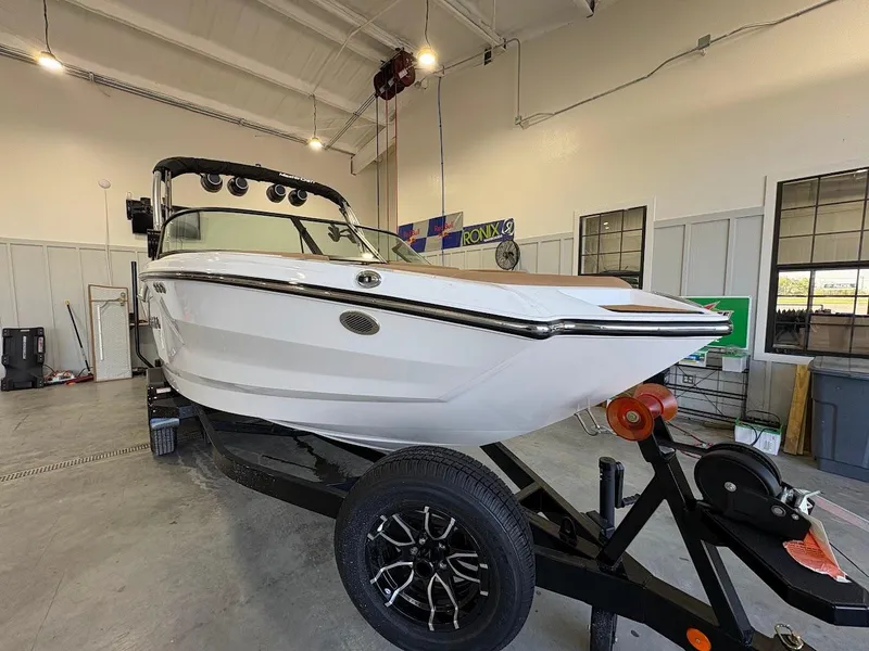 Slide: The Image of 2025 MasterCraft NXT23 boat on trailer in indoor storage facility. - 6