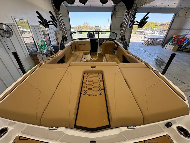 Slide: The Image of 2025 MasterCraft NXT23 boat interior with tan seating and sleek design. - 8