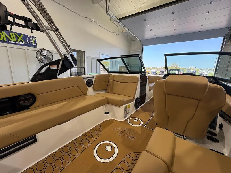 Slide: The Image of 2025 MasterCraft NXT23 boat interior with tan seating and modern design. - 9