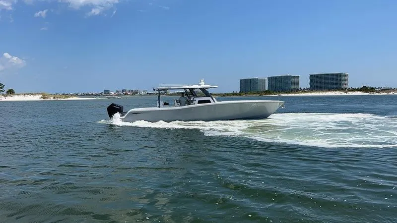 Slide: The Image of 2024 Invincible 43 Open Fisherman cruising on water near modern buildings. - 1