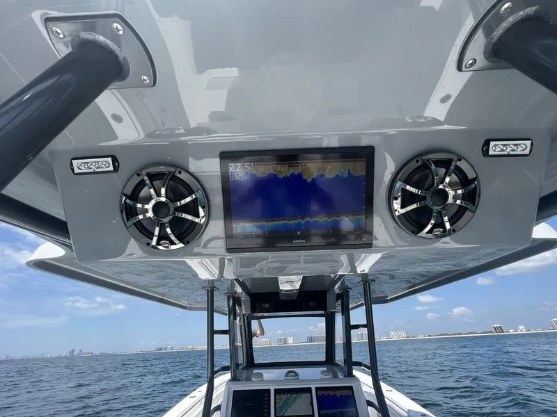 Slide: The Image of 2024 Invincible 43 Open Fisherman dashboard with navigation screen and speakers on open water. - 11