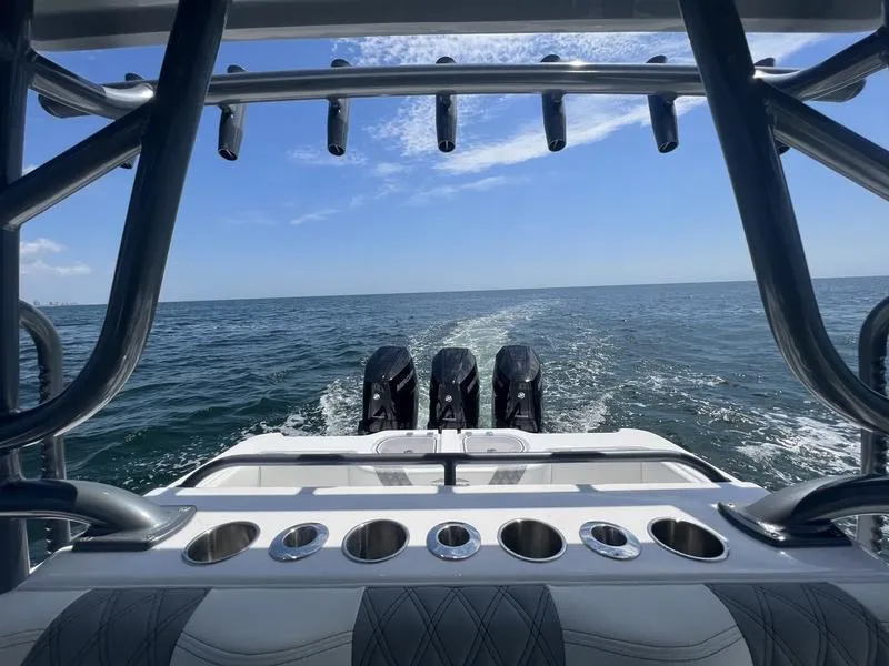Slide: The Image of 2024 Invincible 43 Open Fisherman boat cruising on open water, featuring multiple rod holders. - 23