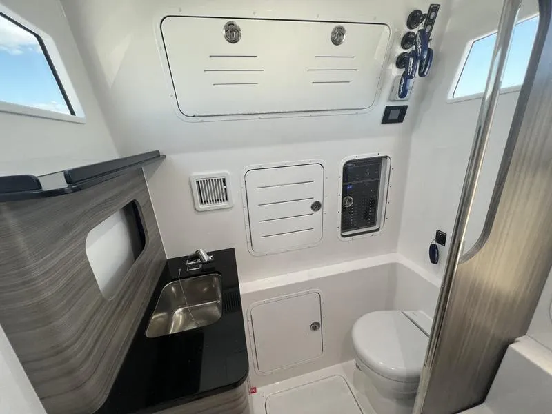 Slide: The Image of 2024 Invincible 43 Open Fisherman boat interior with sink, toilet, and control panel. - 24