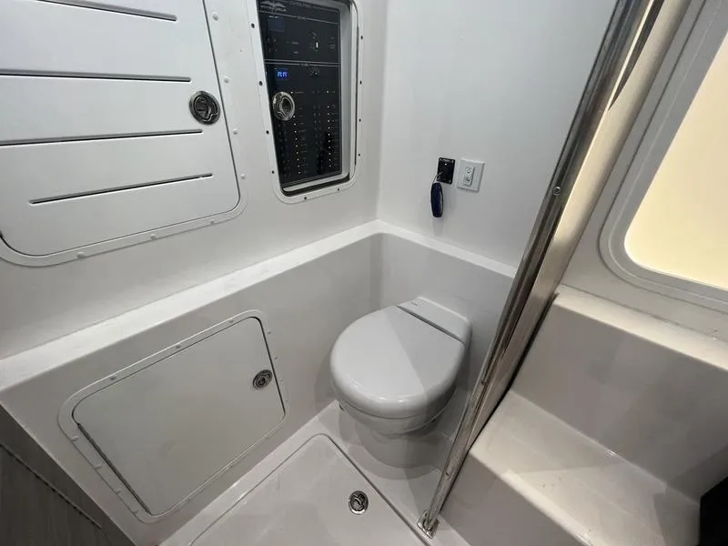 Slide: The Image of 2024 Invincible 43 Open Fisherman boat bathroom with modern fixtures and control panel. - 25