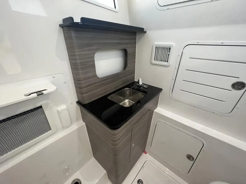 Slide: The Image of 2024 Invincible 43 Open Fisherman interior with compact sink and modern cabinetry. - 26