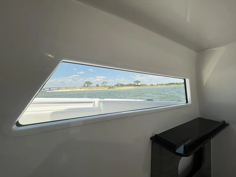 Slide: The Image of Interior view of 2024 Invincible 43 Open Fisherman, showcasing window and water scenery. - 29