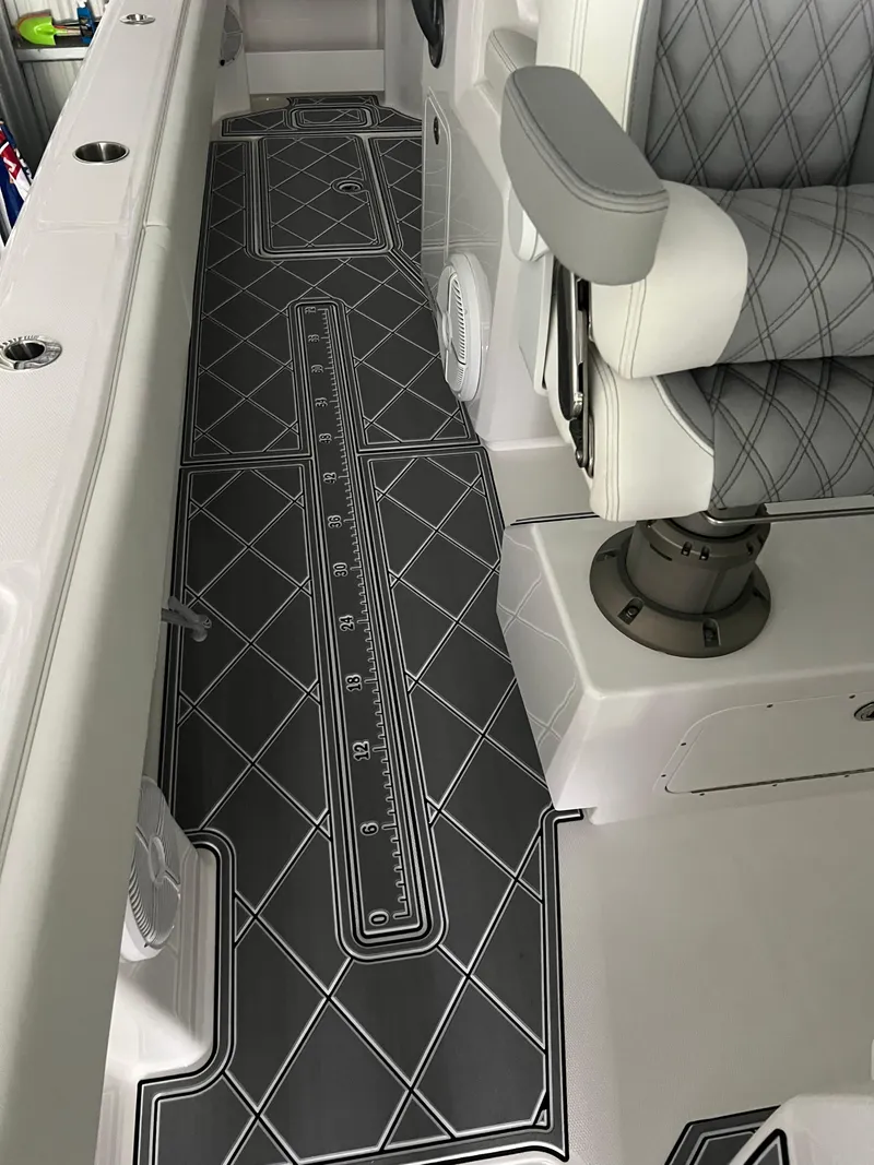 Slide: The Image of 2024 Invincible 43 Open Fisherman boat interior with diamond-patterned flooring and cushioned seating. - 33