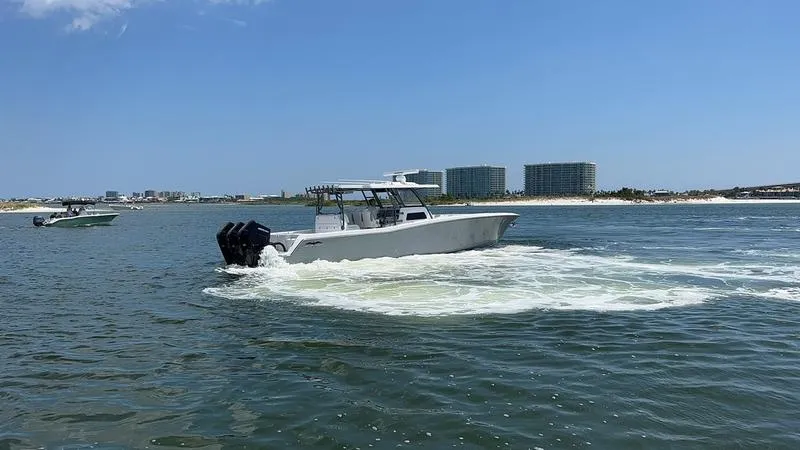 Slide: The Image of 2024 Invincible 43 Open Fisherman boat cruising on a sunny day near the shoreline. - 5