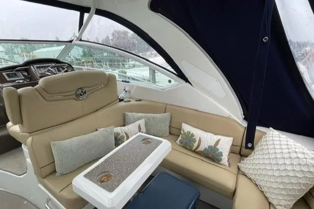 Slide: The Image of 2012 Cruisers Yachts 380 Express interior with beige seating and decorative pillows. - 19