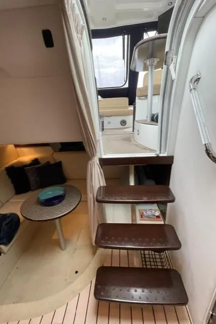 Slide: The Image of Interior of 2012 Cruisers Yachts 380 Express, featuring stairs and cozy seating area. - 22