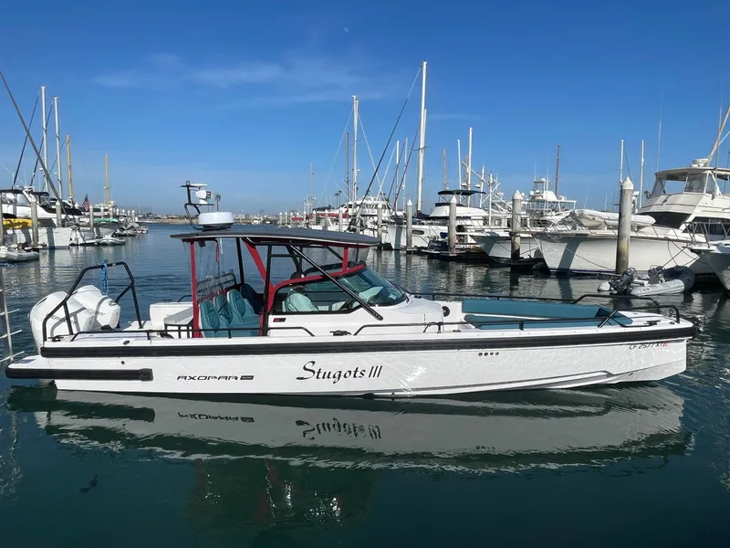 Slide: The Image of 2021 Axopar 28 Brabus T-Top boat docked in a marina. - 1