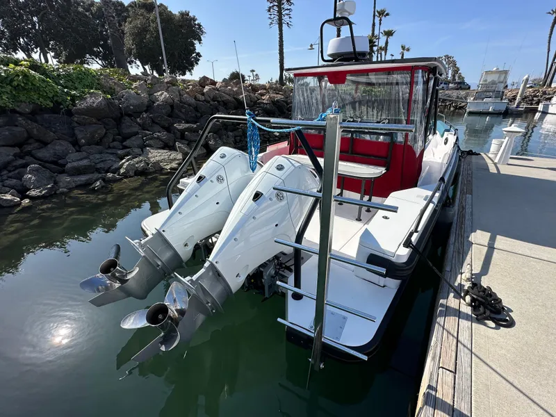 Slide: The Image of 2021 Axopar 28 Brabus T-Top boat docked with dual outboard engines. - 4