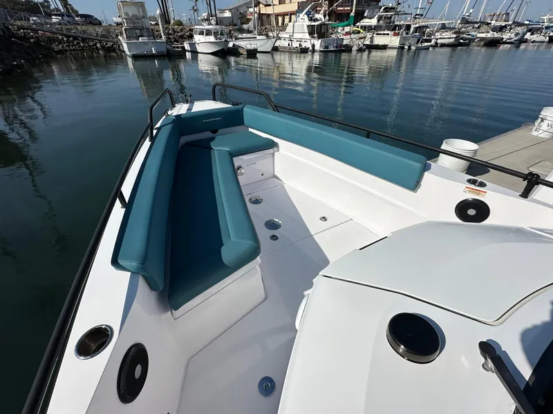 Slide: The Image of Axopar 28 Brabus T-Top 2021 boat with teal seating, docked in a marina. - 6