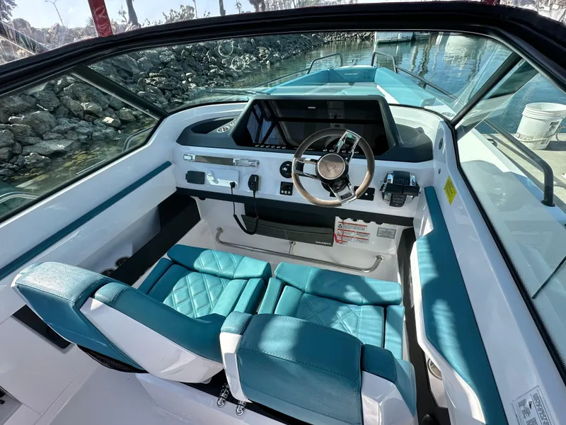 Slide: The Image of 2021 Axopar 28 Brabus T-Top boat interior with teal seats and modern dashboard. - 8