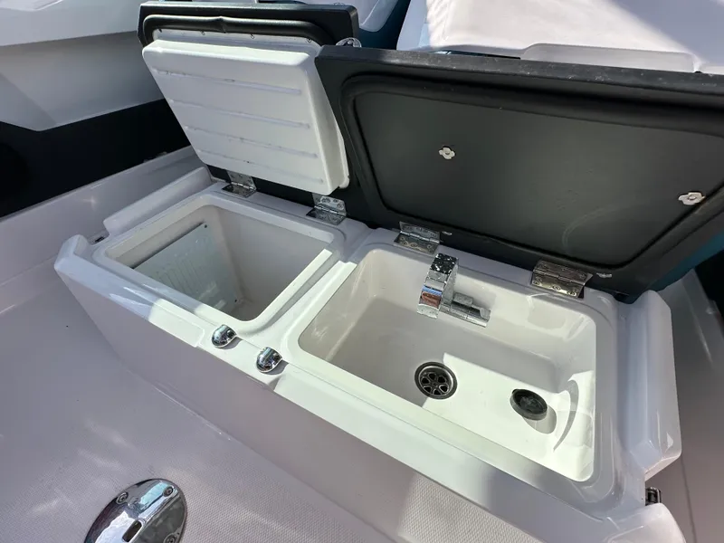 Slide: The Image of 2021 Axopar 28 Brabus T-Top boat with open storage compartments. - 9