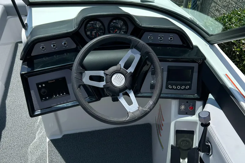Slide: The Image of 2022 MasterCraft NXT24 boat dashboard with steering wheel and control panel. - 7