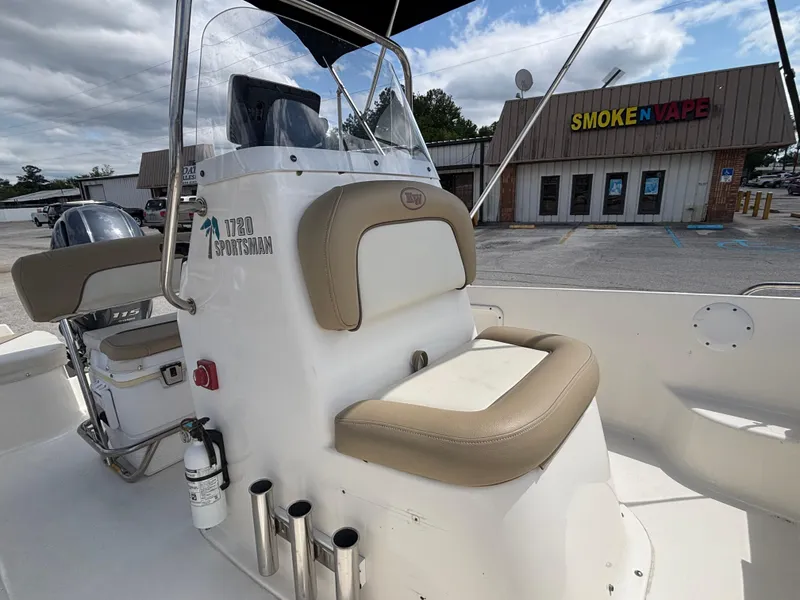 Slide: The Image of 2018 Key West 1720 Sportsman boat interior with seating, parked near a store. - 22