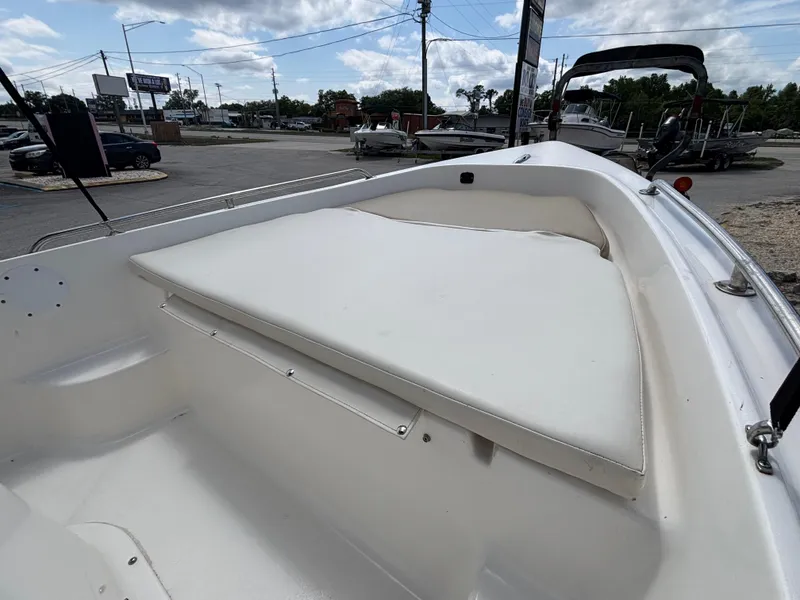 Slide: The Image of 2018 Key West 1720 Sportsman boat with white cushioned seating in a parking lot. - 23