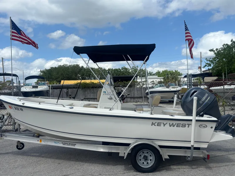Slide: The Image of 2018 Key West 1720 Sportsman boat on trailer, with American flags in the background. - 25