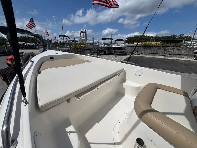 Slide: The Image of 2018 Key West 1720 Sportsman boat with seating, docked under a partly cloudy sky. - 6