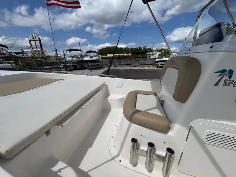 Slide: The Image of 2018 Key West 1720 Sportsman boat interior with seating and rod holders under a blue sky. - 7