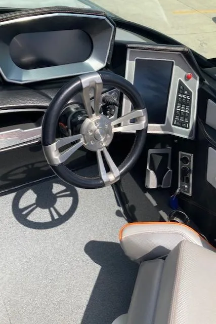 Slide: The Image of Interior of a 2018 MasterCraft X26 boat featuring a modern steering wheel and dashboard. - 10