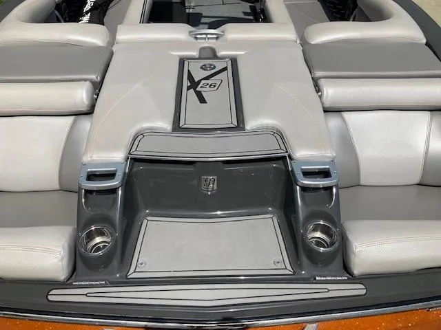 Slide: The Image of 2018 MasterCraft X26 boat interior with gray seating and cup holders. - 6