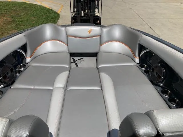 Slide: The Image of 2018 MasterCraft X26 boat interior with gray seating and orange accents. - 9
