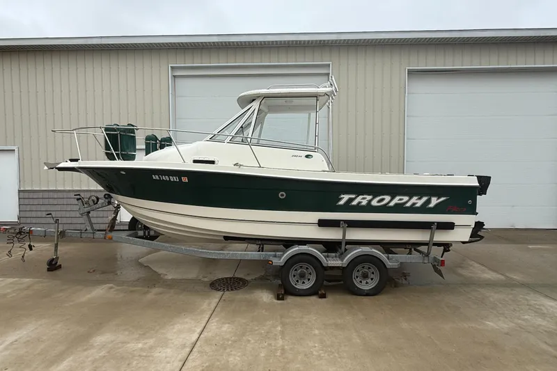Slide: The Image of 2010 Trophy 2152 Walkaround boat on trailer, parked outside a garage. - 0