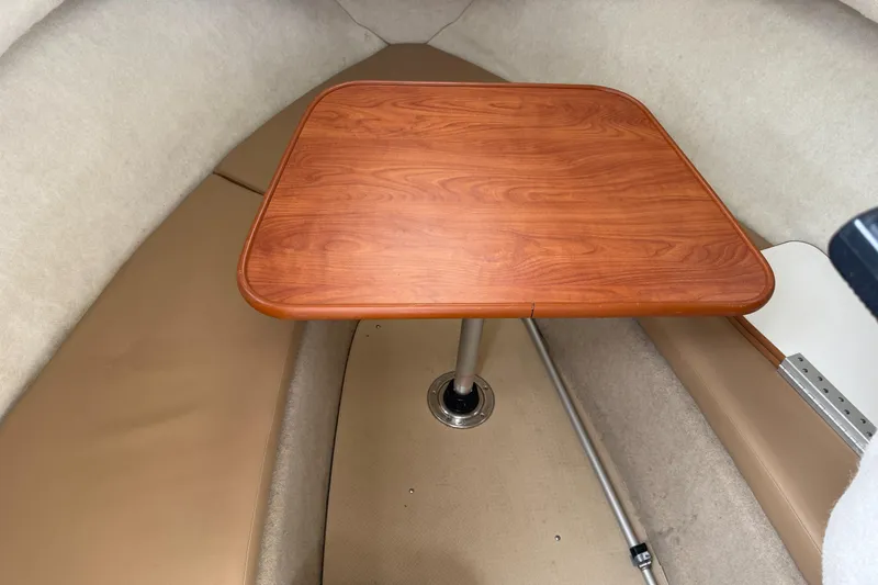 Slide: The Image of 2010 Trophy 2152 Walkaround cabin interior with wooden table and beige seating. - 14