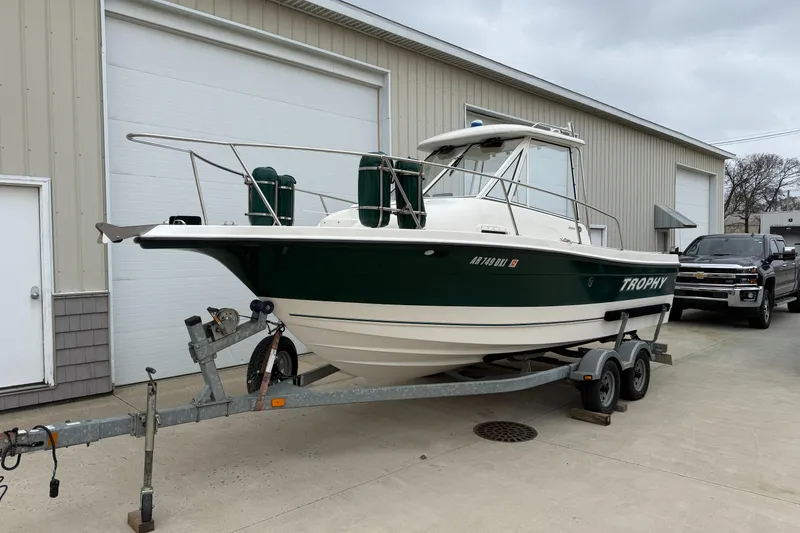 Slide: The Image of 2010 Trophy 2152 Walkaround boat on trailer outside a garage. - 2