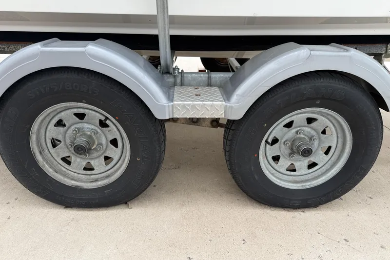 Slide: The Image of Trailer wheels of a 2010 Trophy 2152 Walkaround boat on a sandy surface. - 32