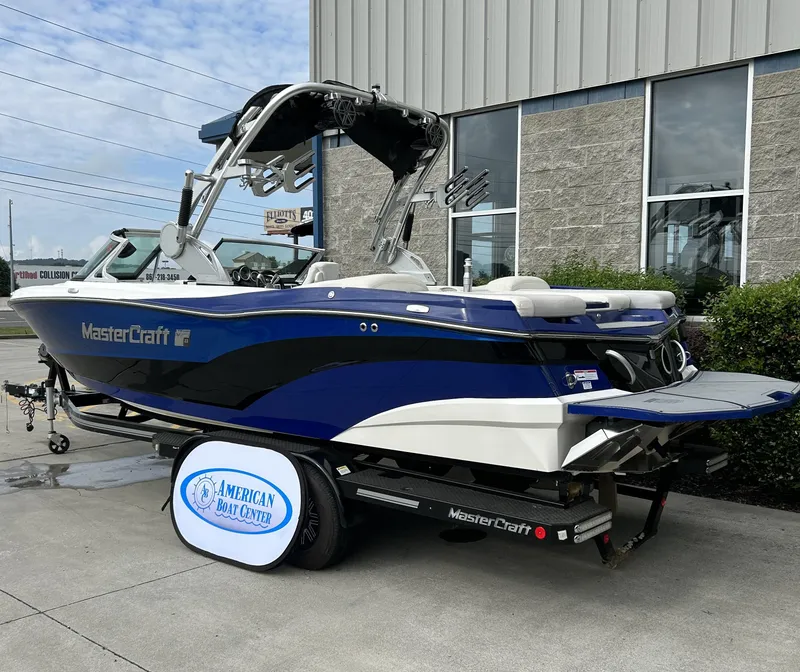 Slide: The Image of 2017 MasterCraft XT23 boat in blue and white, displayed at American Boat Center. - 2