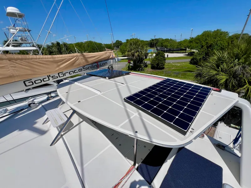 Slide: The Image of Voyage Yachts 500 (2010) with solar panels on deck, docked in a lush marina setting. - 12