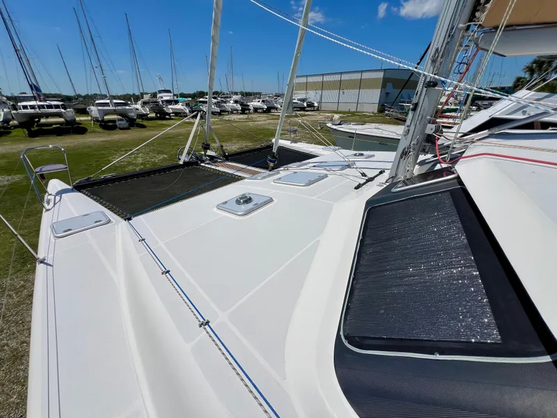 Slide: The Image of 2010 Voyage Yachts 500 catamaran deck with netting, docked near other boats. - 13
