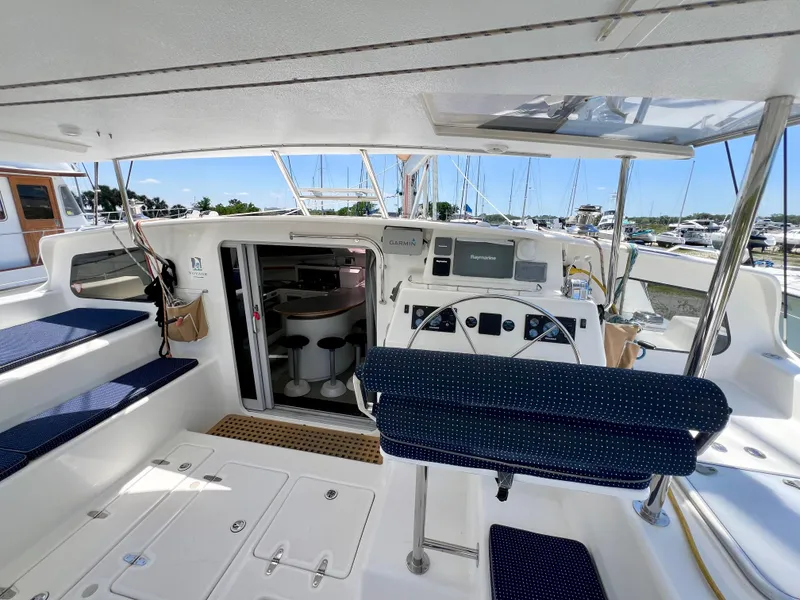 Slide: The Image of Cockpit of 2010 Voyage Yachts 500, featuring navigation controls and seating, docked at marina. - 21