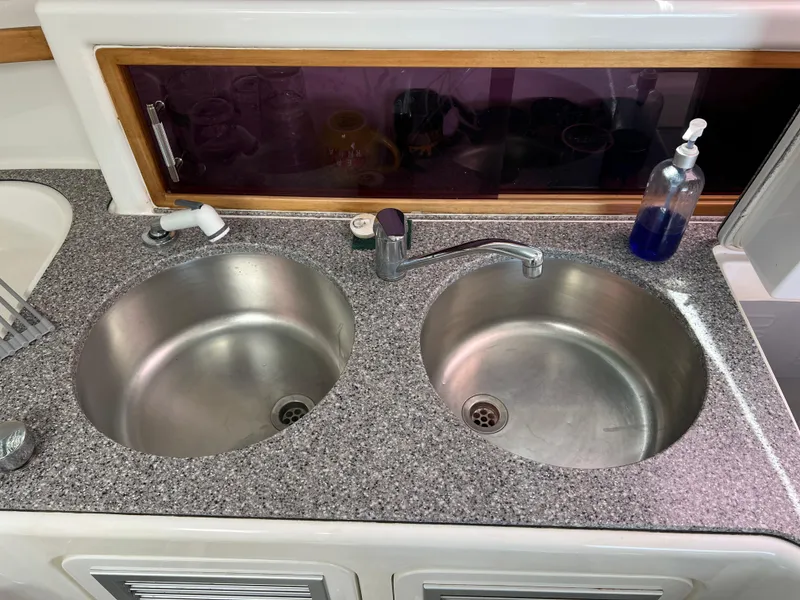 Slide: The Image of Dual stainless steel sinks in Voyage Yachts 500, 2010 model, with granite countertop and soap dispenser. - 32