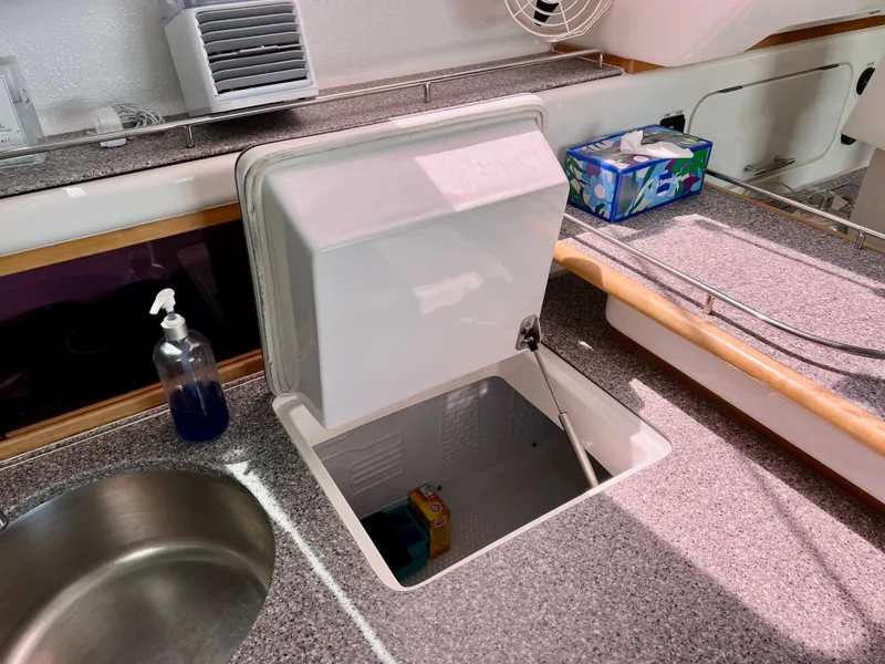 Slide: The Image of Galley sink and storage on 2010 Voyage Yachts 500, featuring countertop and cleaning supplies. - 33
