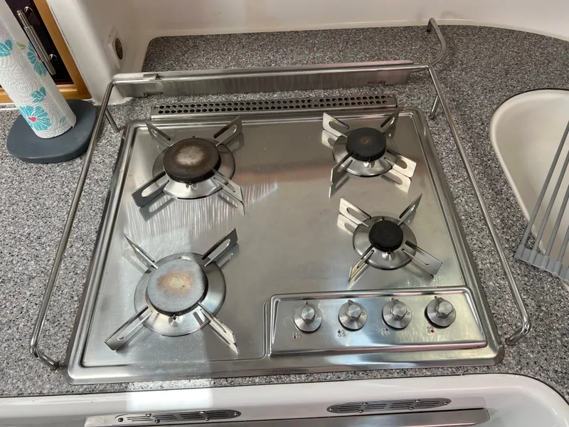 Slide: The Image of Stainless steel four-burner stove on a 2010 Voyage Yachts 500, set in a granite countertop. - 36