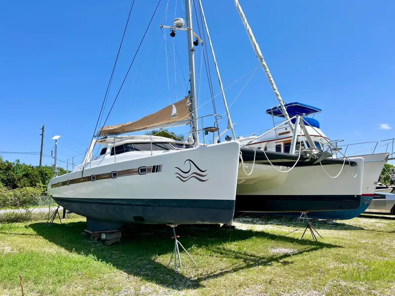 Slide: The Image of Voyage Yachts 500 catamaran, 2010 model, on land under clear blue sky. - 4