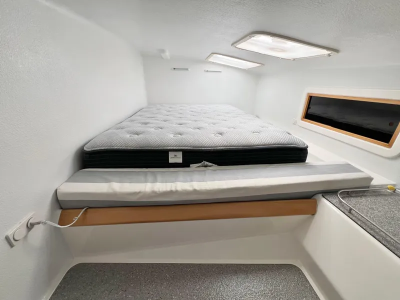 Slide: The Image of Cozy cabin interior of 2010 Voyage Yachts 500 with a comfortable bed and window view. - 49