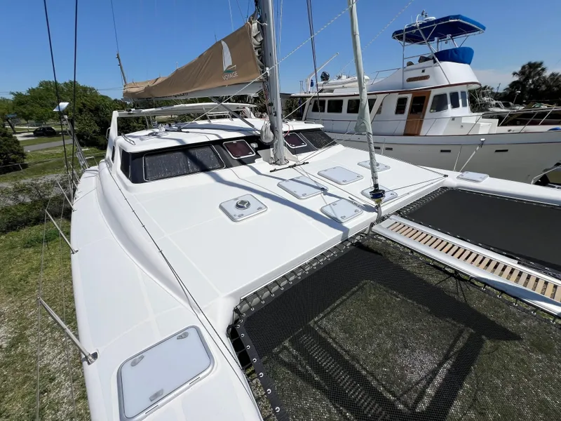 Slide: The Image of Sleek 2010 Voyage Yachts 500 catamaran docked, showcasing modern design and spacious deck. - 8