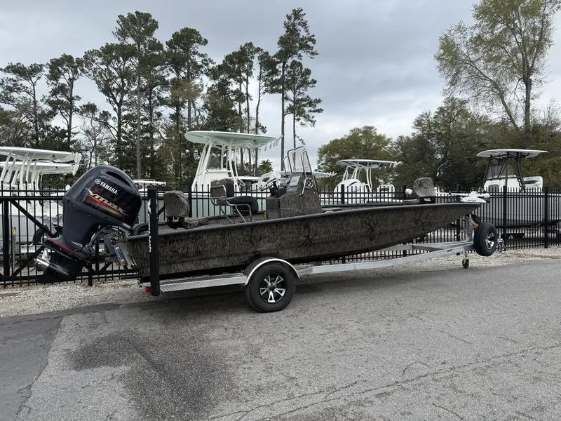 Slide: The Image of 2025 Xpress H22B Bay boat on trailer with Yamaha outboard motor, parked outdoors. - 2