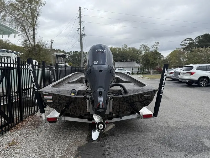 Slide: The Image of 2025 Xpress H22B Bay boat with 150 HP engine on trailer, parked outdoors. - 4