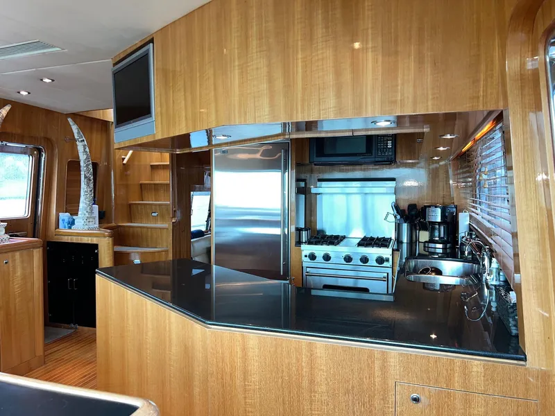 Slide: The Image of Luxurious yacht kitchen with wood cabinetry, modern appliances, and sleek black countertops. Horizon Skylounge 2001. - 23