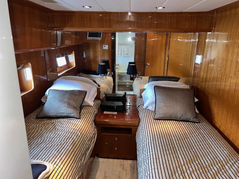 Slide: The Image of Luxurious twin cabin interior of 2001 Horizon Skylounge yacht with wood paneling and striped bedding. - 32