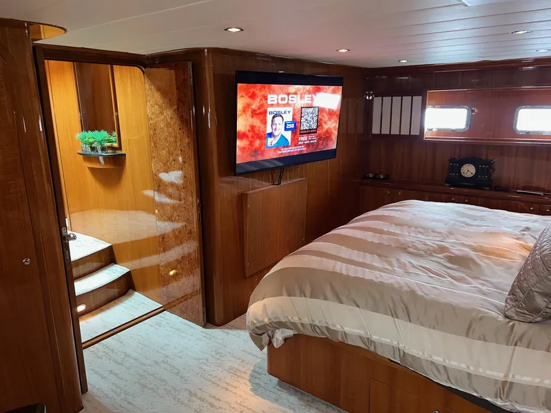 Slide: The Image of Luxurious 2001 Horizon Skylounge yacht bedroom with TV, wooden decor, and cozy bedding. - 39
