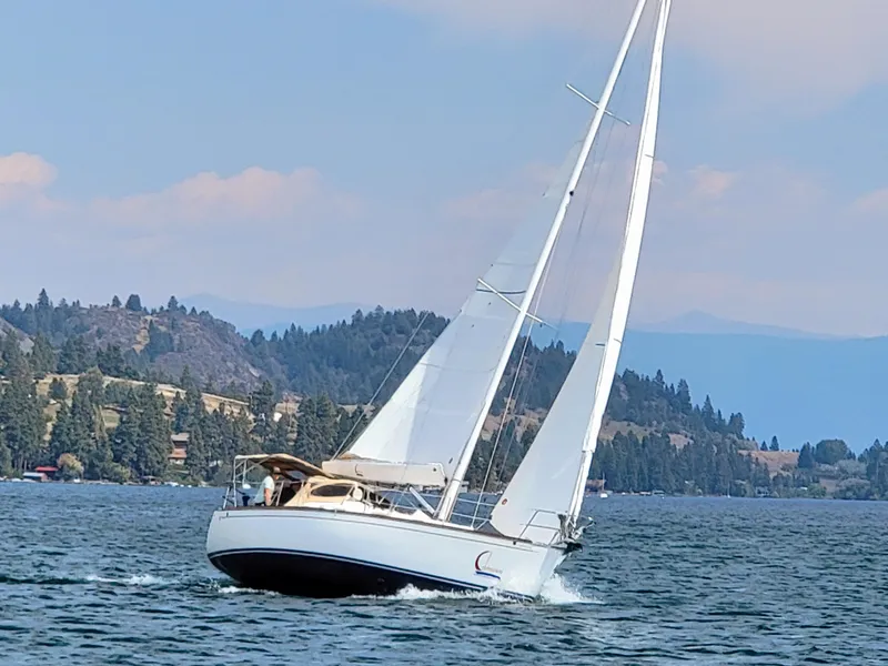 Slide: The Image of Sailboat Tartan 3400 (2007) cruising on a scenic lake with forested hills. - 1
