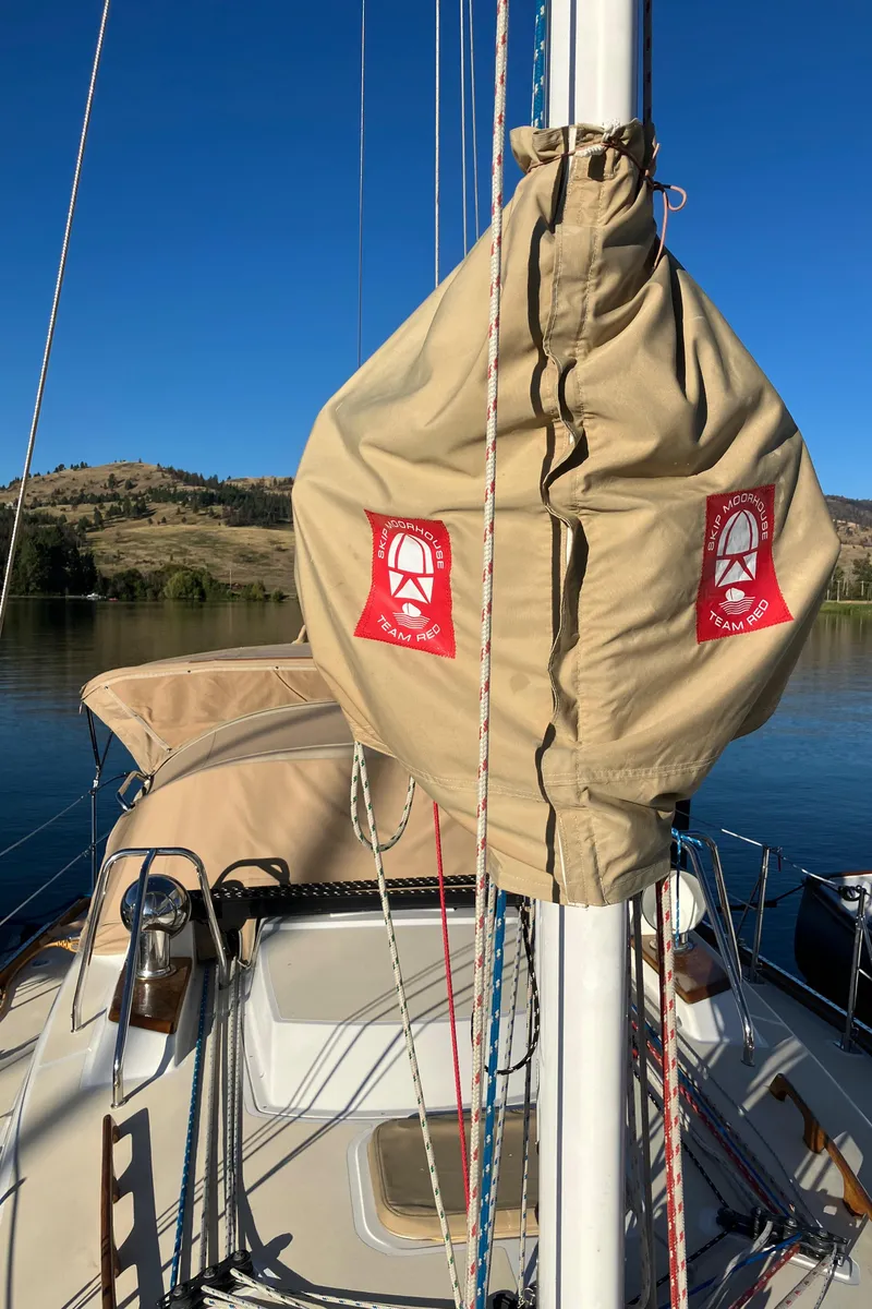 Slide: The Image of 2007 Tartan 3400 sailboat with beige sail cover, docked on a serene lake. - 10