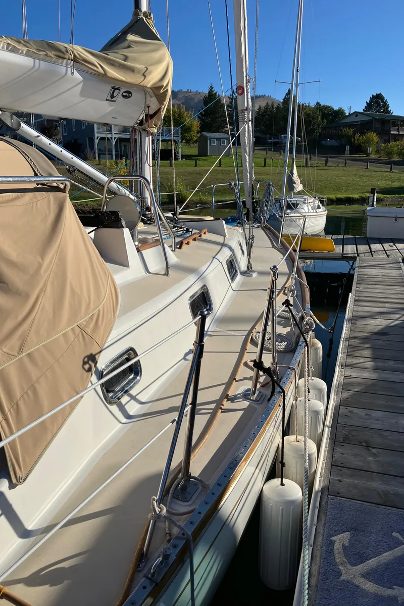 Slide: The Image of 2007 Tartan 3400 sailboat docked, featuring beige covers and sleek design. - 12